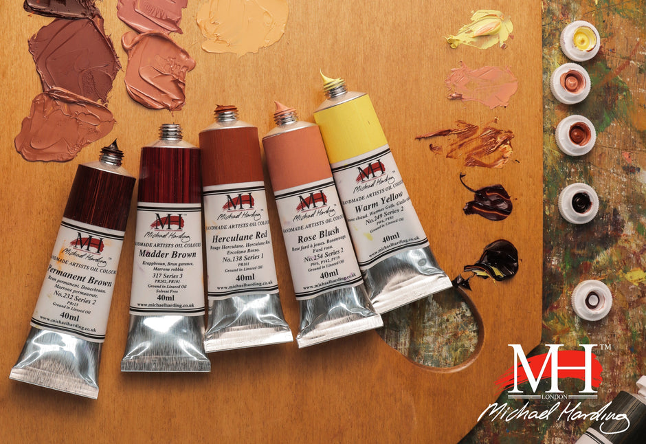 Five tubes of Michael Harding Cook’s Yard oil colours displayed with paint swatches on a wooden surface.