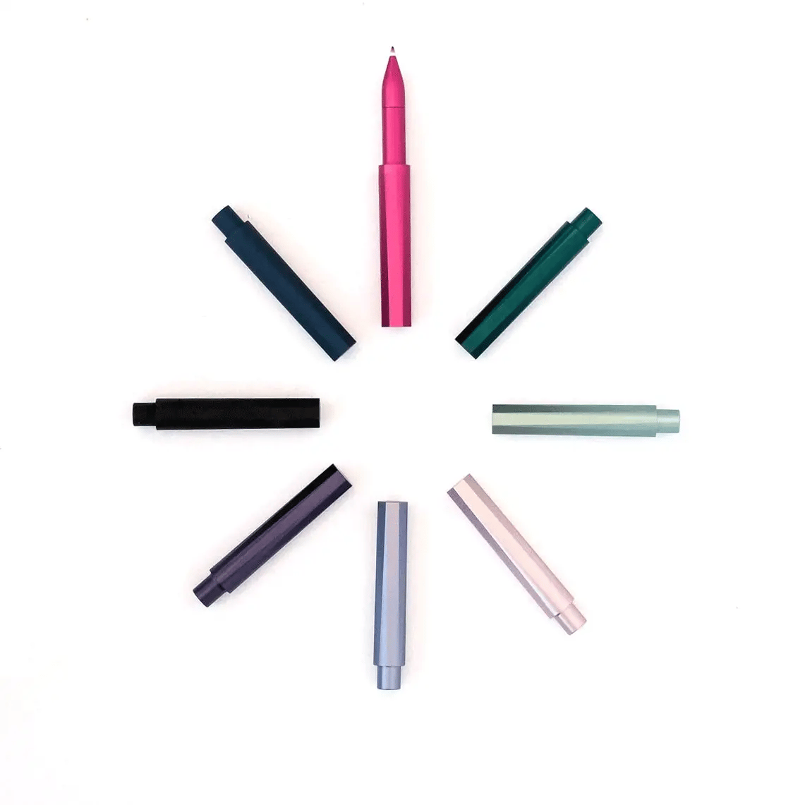 Assorted colored pens from Tom's Studio BradburyART arranged in a circle on a white background.