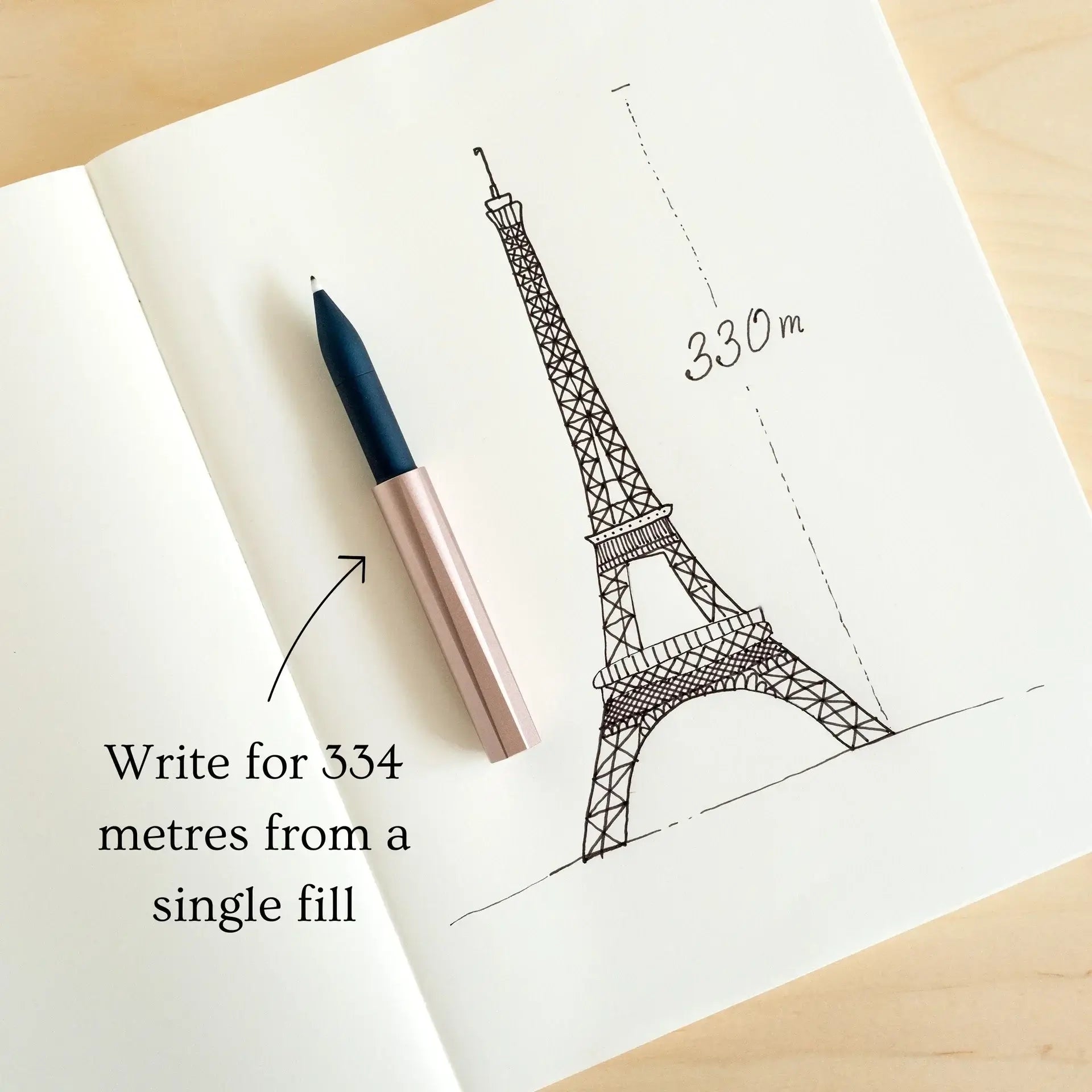 Pen and Eiffel Tower sketch in a premium stationery collection notebook with writing distance indication.