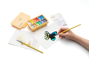 HIMI Twin Cup Gouache Set - 12 Colours (Yellow Case Metallic Edition) shown in use.