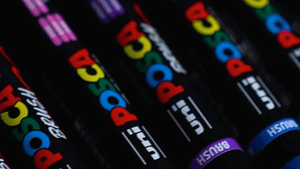 Close-up of POSCA Brush PC-5BR paint pens in various colors, ideal for fine details or bold strokes on multiple surfaces.