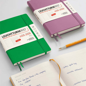 Leuchtturm 2026 Pocket Weekly Planner & Notebook in green and purple covers with a pen, featuring weekly planner and notes.