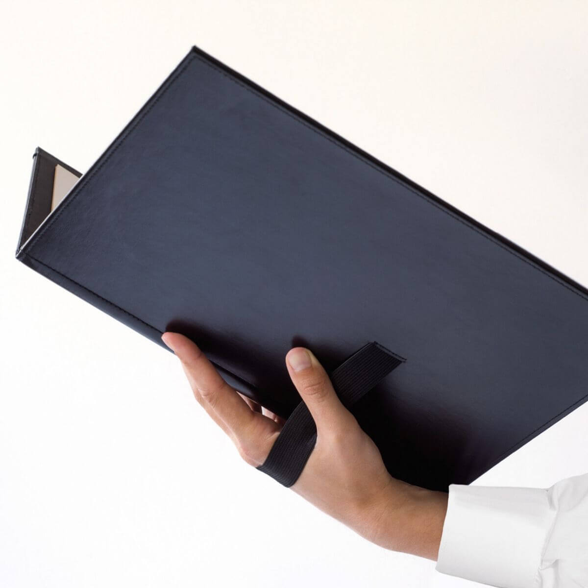 Leuchtturm Music Portfolio DIN A4 with Elastic Strap & Corner Pockets, black folder held by a hand, stylish for musicians