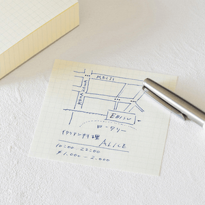 MD Block memo pad with handwritten map and notes on grid paper beside a silver pen.