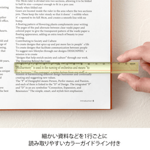 Using Midori Lens Ruler 15cm – Yellow to magnify text on a document, highlighting built-in magnifying lens and guideline feature.