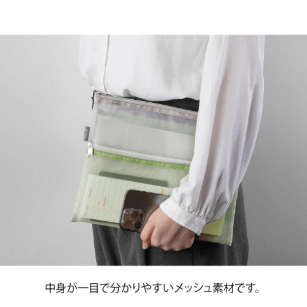 Person holding Midori Pen & Tool Pouch B5 – Mesh Green with items visible inside through mesh material.