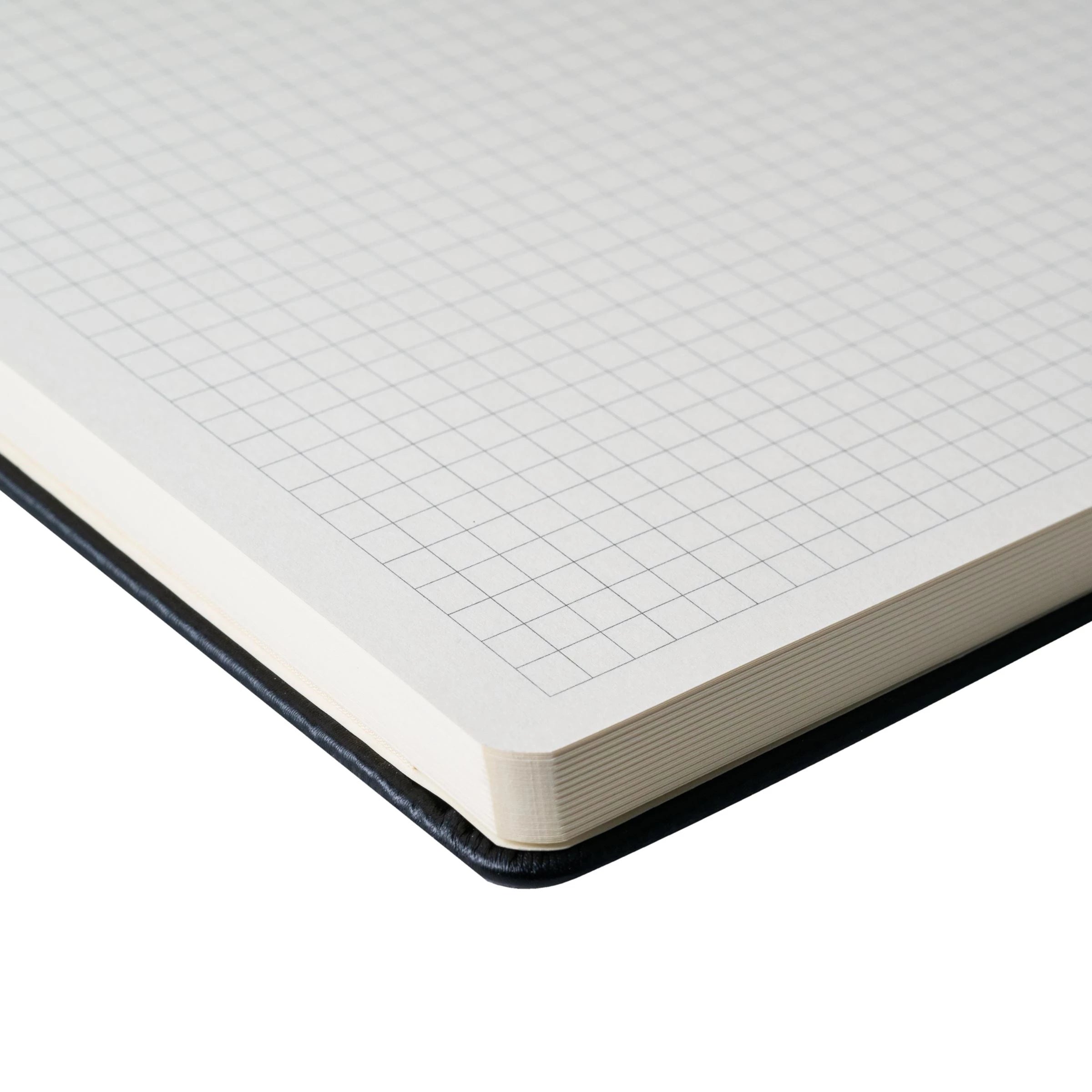 Close-up of squared cream white paper in the Sakura A4 hard cover notebook, featuring rounded corners and durable design.