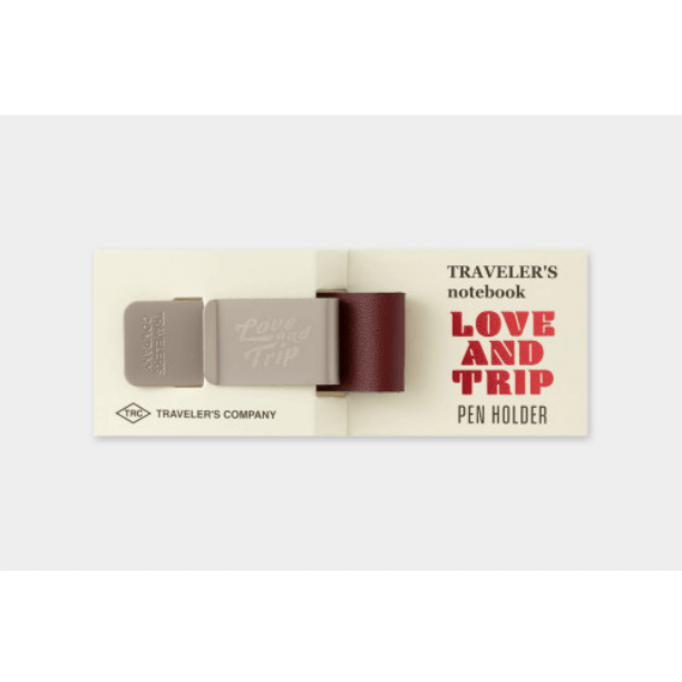 TRAVELER’S notebook Pen Holder – LOVE AND TRIP Red with engraved metal clip and red leather holder on packaging.