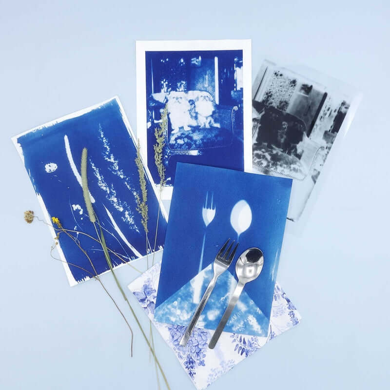 Cyanotype Refill Set – 2×1000 ml Sensitiser Bottles for Sun‑Print Printing on display with artistic sun-prints and utensils.