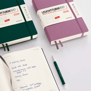 Leuchtturm 2026 Daily Planner in medium A5 hardcover, featuring purple and green covers with full-page daily layout on open page.