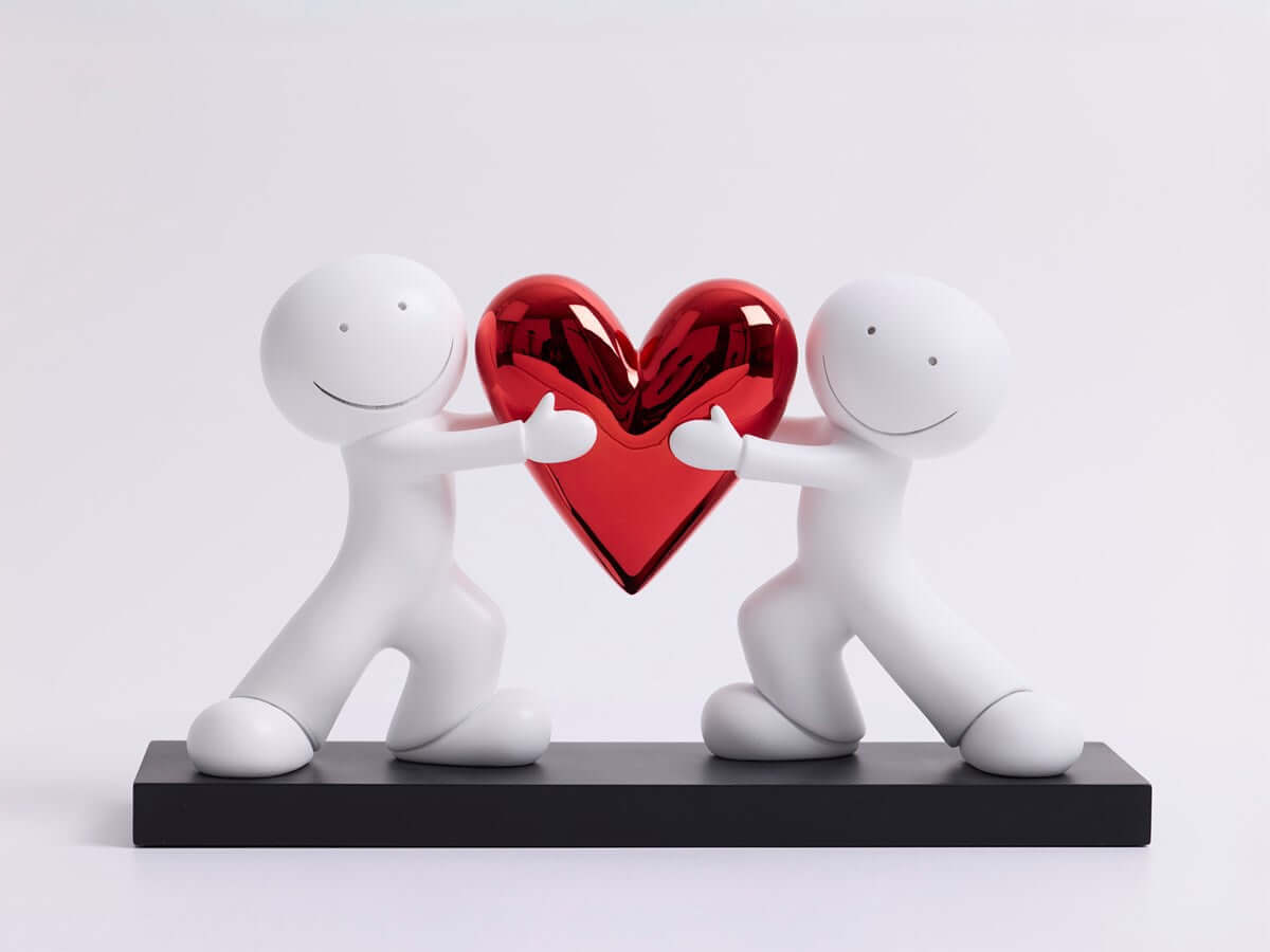 Heart to Heart Sculpture by Doug Hyde featuring two figures holding a red heart, symbolizing unity and balance in a contemporary design.