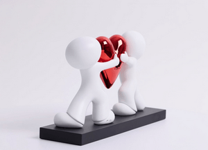 Heart to Heart Sculpture by Doug Hyde featuring two figures holding a red heart