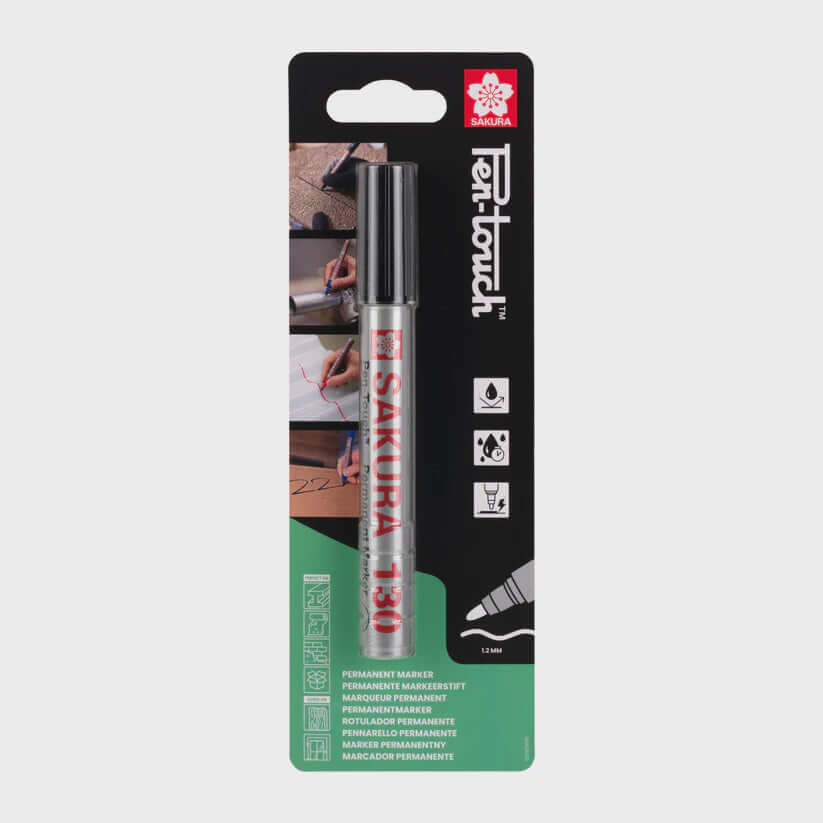 Sakura Pen-Touch 130 Black marker in packaging, showing bullet-shaped tip for versatile use on cardstock, plastic, wood, glass, and metal.