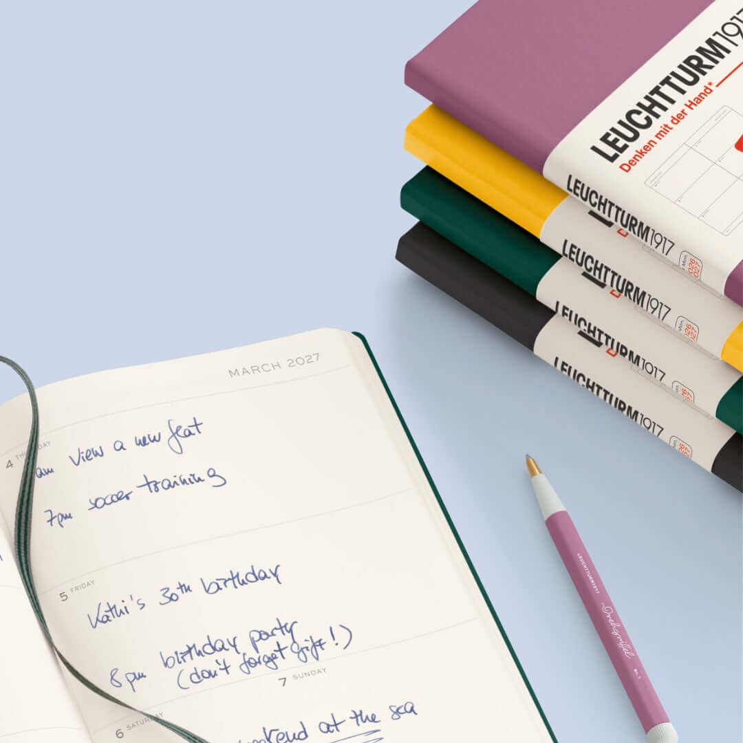 Leuchtturm1917 A5 weekly planner 2027 opened to March 2027, surrounded by colorful hardcover covers.